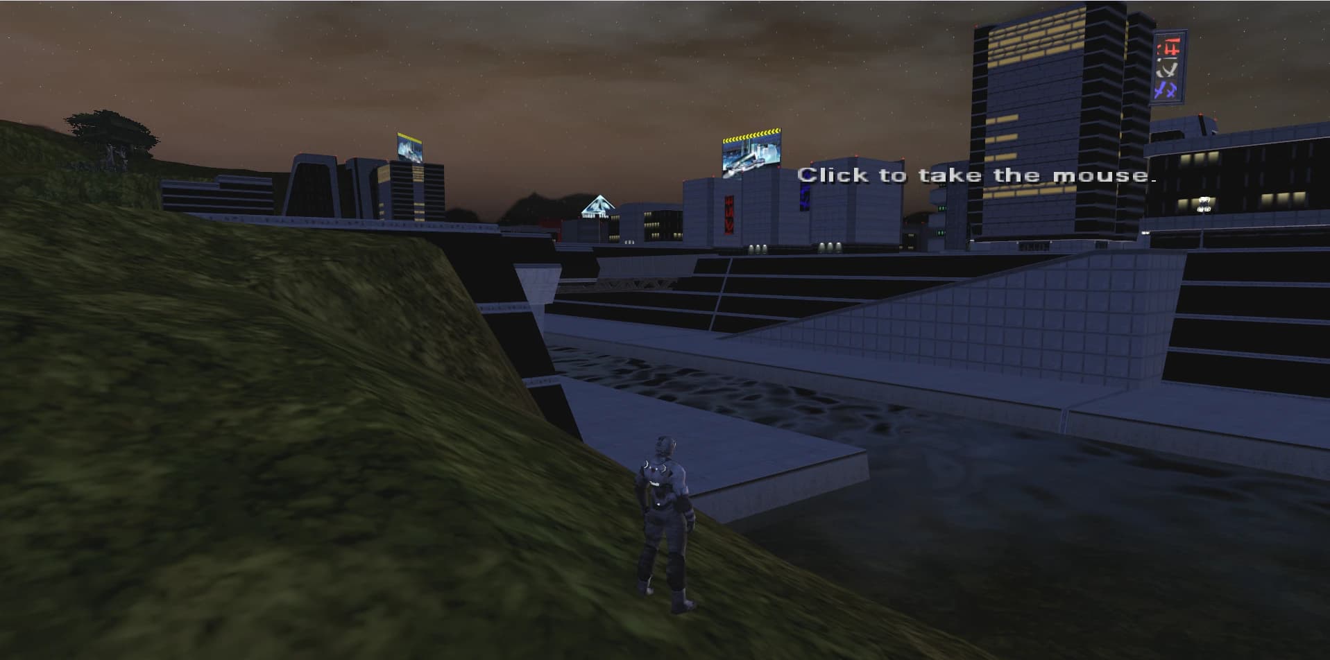 The pilot on a grassy slope above the GoCommando waterfront, with water, stepped concrete embankments, and tower blocks with lit windows behind